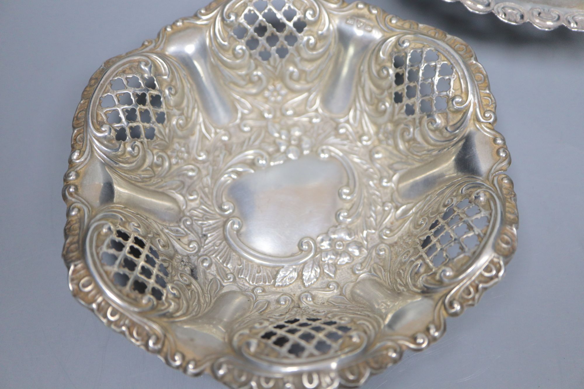 A late Victorian repousse silver bon bon dish and two similar Edwardian dishes, largest 16.8cm, 159 grams.